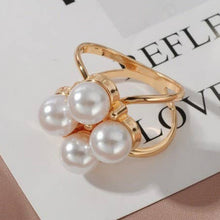Load image into Gallery viewer, Gold ring with pearls on a magazine page